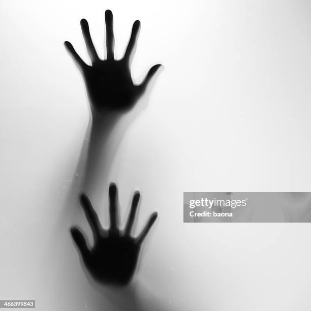 two hands in silhouette pressed against frosted glass - scary shadow stock pictures, royalty-free photos & images