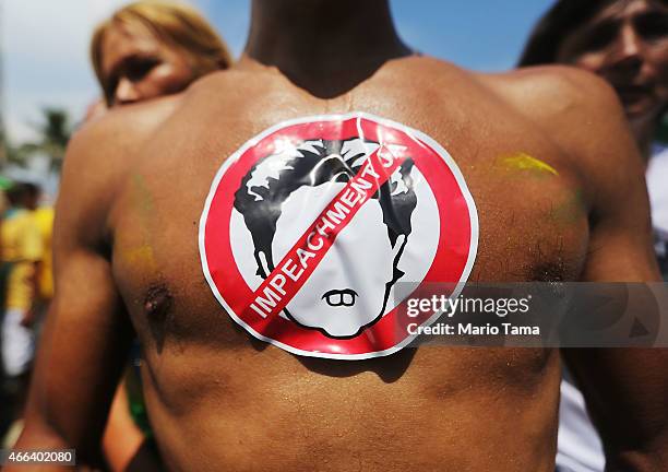 Man wears a sticker calling for impeachment while marching along Copacabana beach on March 15, 2015 in Rio de Janeiro, Brazil. Protests across the...