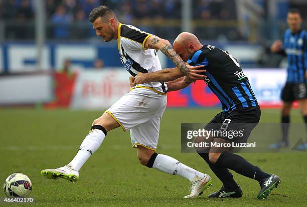 Cyril Thereau of Udinese Calcio is challenged by Giulio Migliaccio of Atalanta BC during the Serie A match between Atalanta BC and Udinese Calcio at...