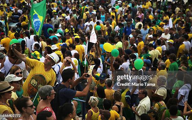 Man takes a selfie with anti-government protesters along Copacabana beach on March 15, 2015 in Rio de Janeiro, Brazil. Protests across the country...