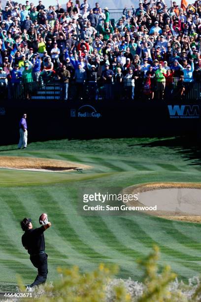 Phil Mickelson throws a football to the crowd on the 16th hole during the third round of the Waste Management Phoenix Open at TPC Scottsdale on...