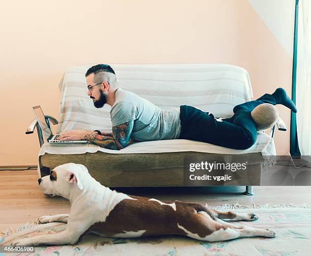 man and his best friend dog at home. - lying on front stock pictures, royalty-free photos & images