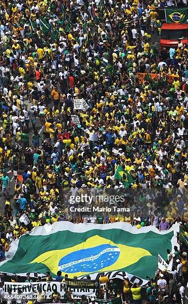 Anti-government protesters march carrying a Brazilian flag along Copacabana beach on March 15, 2015 in Rio de Janeiro, Brazil. Protests across the...