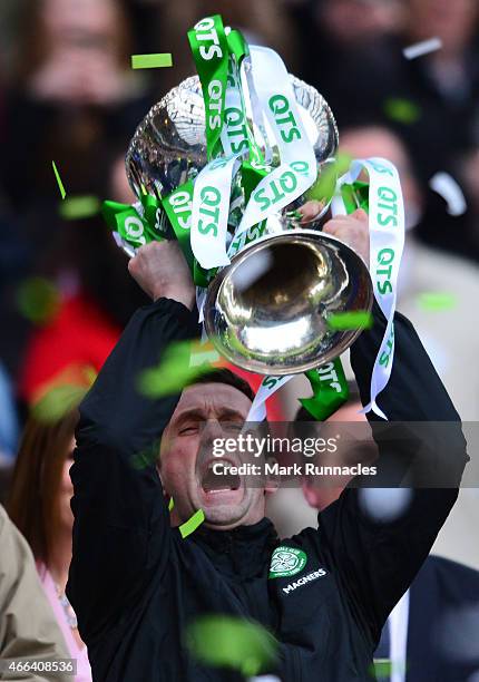 Celtic manager Ronny Deila lifts the League Cup trophy as the Celtic team celebrate during the Scottish League Cup Final between Dundee United and...