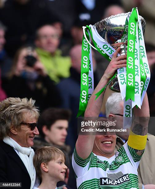 Celtic captain Scott Brown is presented with the League Cup trophy by life long Celtic fan Rod Stewart , as the Celtic team celebrate during the...