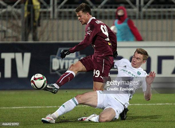 Maksim Kanunnikov of FC Rubin Kazan is challenged by Andrei Semyonov of FC Terek Grozny during the Russian Premier League match between FC Rubin...