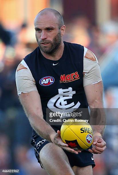 Chris Judd of the Blues handballs during the NAB Challenge AFL match between the Collingwood Magpies and the Carlton Blues at Queen Elizabeth Oval on...