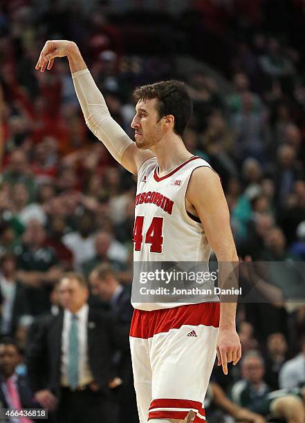 Frank Kaminsky of the Wisconsin Badgers holds up his arm after hitting a three point shot against the Michigan State Spartans during the Championship...