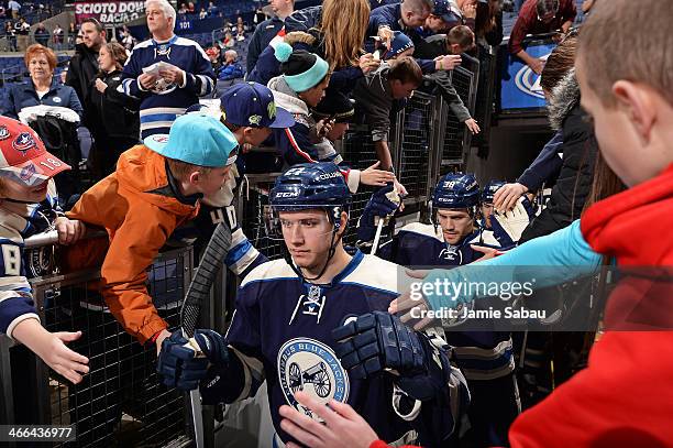 Ryan Murray and Boone Jenner of the Columbus Blue Jackets high-five fans as they take the ice for warm-ups prior to a game against the Florida...