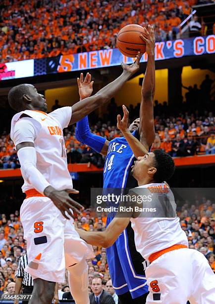 Baye Moussa Keita and and Michael Gbinije of the Syracuse Orange and Rasheed Sulaimon of the Duke Blue Devils react to a loose ball during the first...