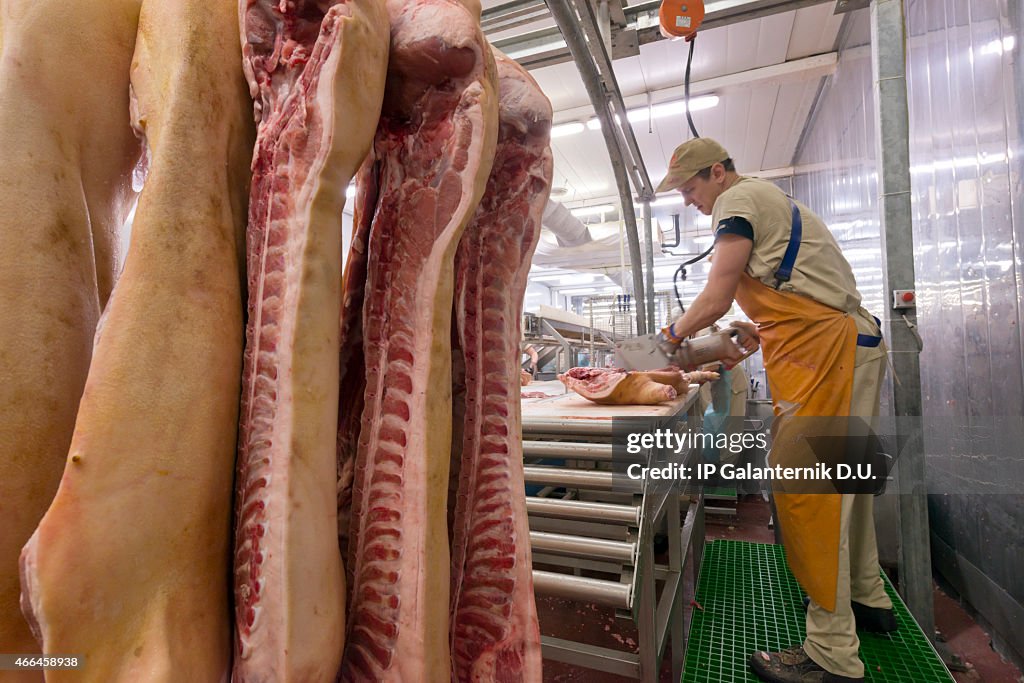 Butcher cutting meat on the Food Processing Plant