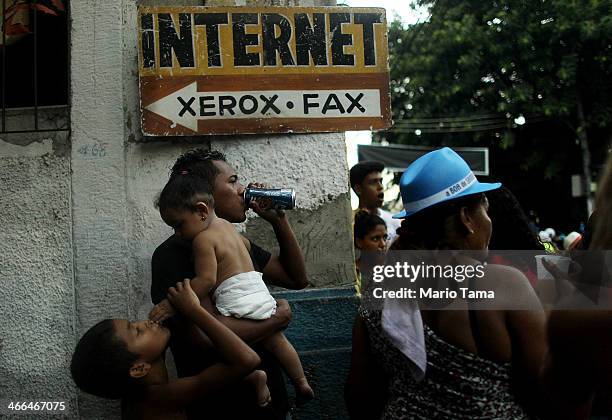Onlookers watch during the first street parade of the 2014 Carnival season through the historic Afro-Brazilian port district during the Circuito da...