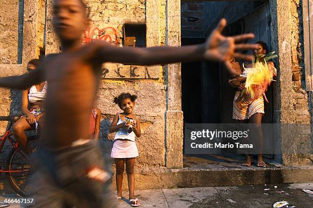 People gather as others march in the first street parade of the 2014 Carnival season through the historic Afro-Brazilian port district during the...