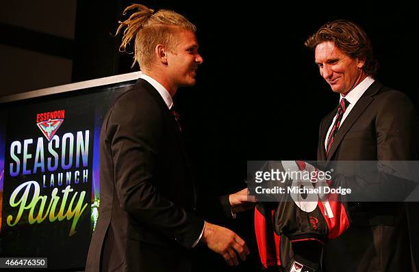 Michael Hurley of the Bombers is presented his jumper by coach James Hird reacts during the Essendon Bombers 2015 AFL season launch at Luminare on...