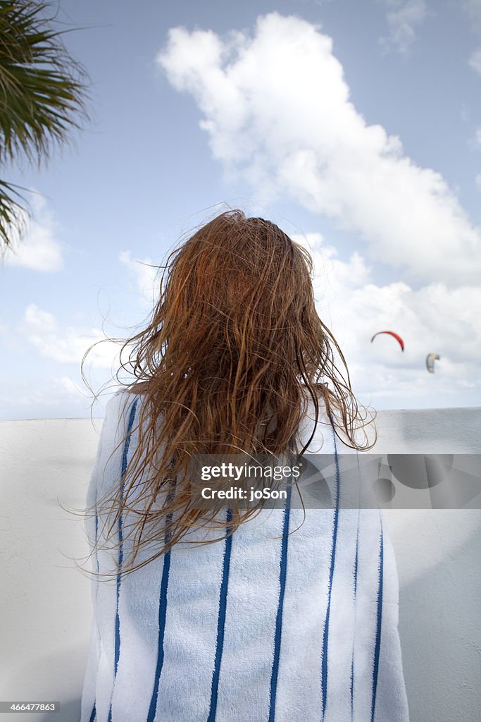 Girl standing at balcony, cover with towel
