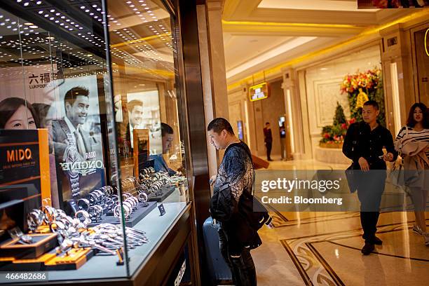 Visitor looks in the window of a store selling watches at the Galaxy Macau casino resort, operated by Galaxy Entertainment Group Ltd., in Macau,...