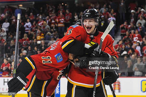 Ladislav Smid congratulates Mikael Backlund of the Calgary Flames after Mikael Backlund scored the game-winning goal against the Minnesota Wild...