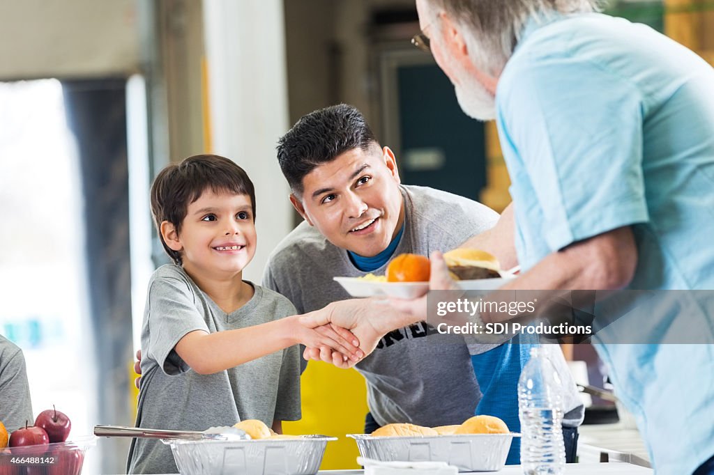 Father and son volunteering in soup kitchen together