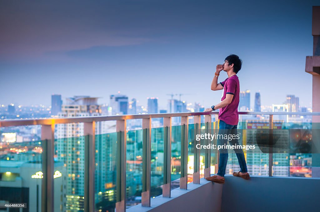 Men standing on the rooftop of a skyscraper over  cityscape