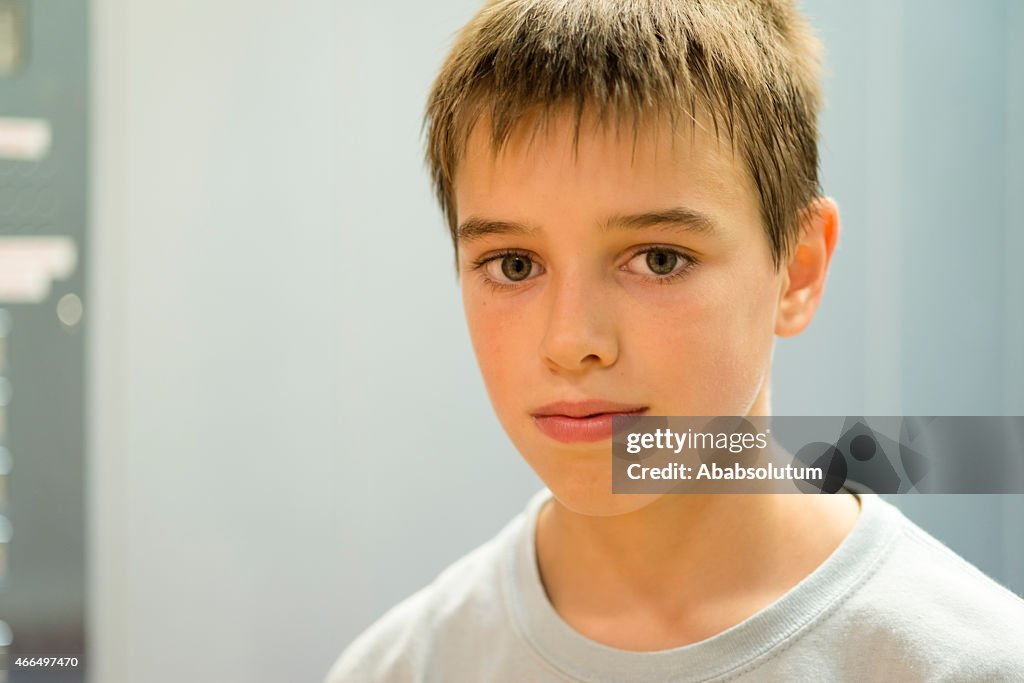 Portrait of Pensive Eleven Years Old Boy, Gray Wall, Europe