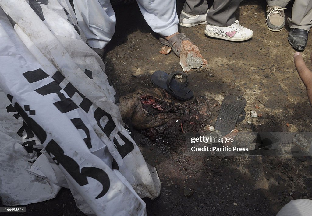 People gather around the burning bodies of what the mob...