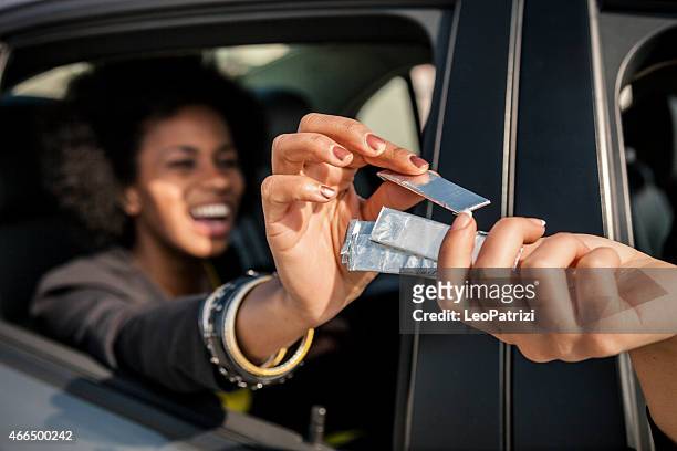 femme passant chewing-gum de la fenêtre de voiture - passing giving photos et images de collection
