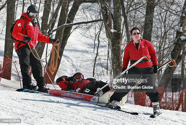 Three members of the National Ski Patrol are pictured at the Blue Hills Ski Area as they participate in a training exercise. In front is Mary Thomas,...