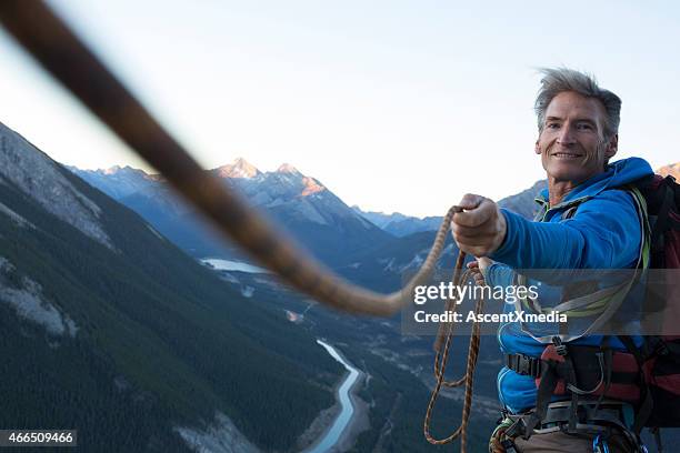 climber pulls rope tight for teammate - expert guidance stock pictures, royalty-free photos & images