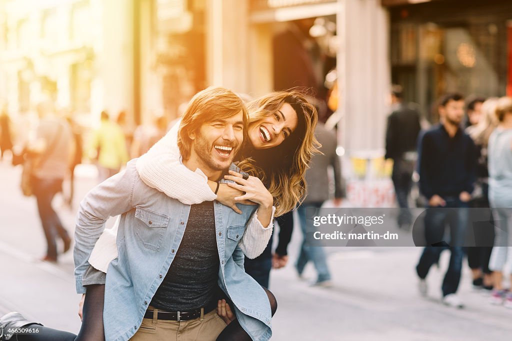 Young man carrying his girlfriend at piggyback