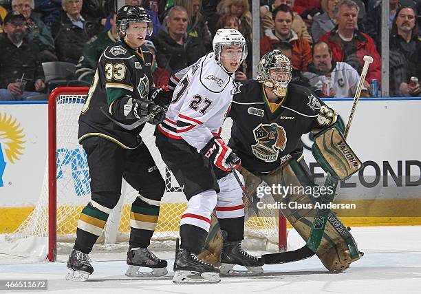 Zach Nastasiuk of the Owen Sound Attack waits fro a shot to tip between Julius Bergman and Michael Giugovaz of the London Knights during an OHL game...