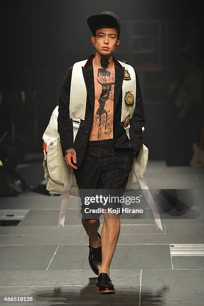 Model showcases designs on the runway during the TAKEO KIKUCHI show as part of Mercedes Benz Fashion Week TOKYO 2015 A/W at Shibuya Hikarie on March...