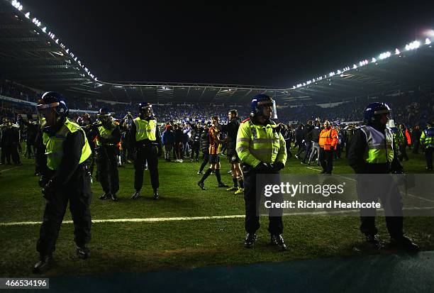 Police monitor fans as they invade the pitch after the FA Cup Quarter Final Replay match between Reading and Bradford City at Madejski Stadium on...
