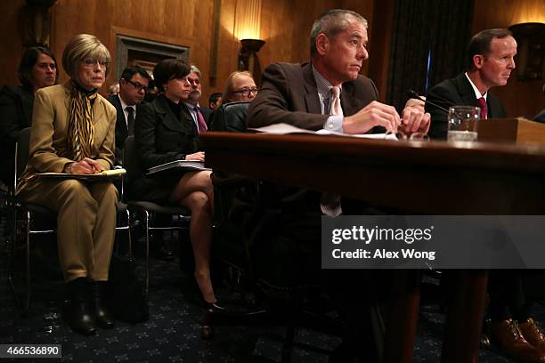 Judy Rivers of Logan, Alabama, who twice had been listed in the Social Security Death Master File, listens as senior adviser to the deputy...