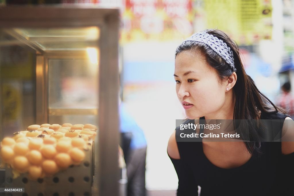 Woman looking at Hong Kong street snacks