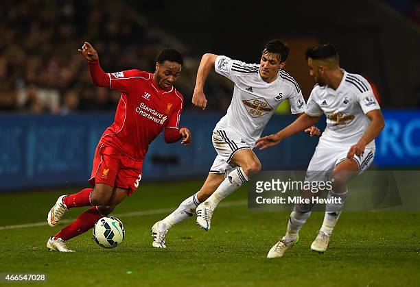 Raheem Sterling of Liverpool takes on Jack Cork and Neil Taylor of Swansea City during the Barclays Premier League match between Swansea City and...