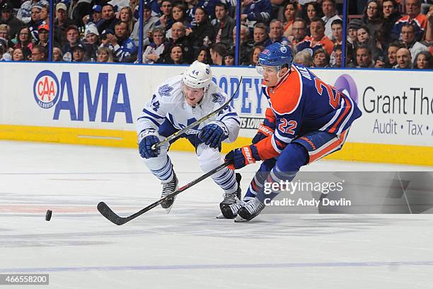 Keith Aulie of the Edmonton Oilers battles for the puck against Morgan Rielly of the Toronto Maple Leafs on March 16, 2015 at Rexall Place in...