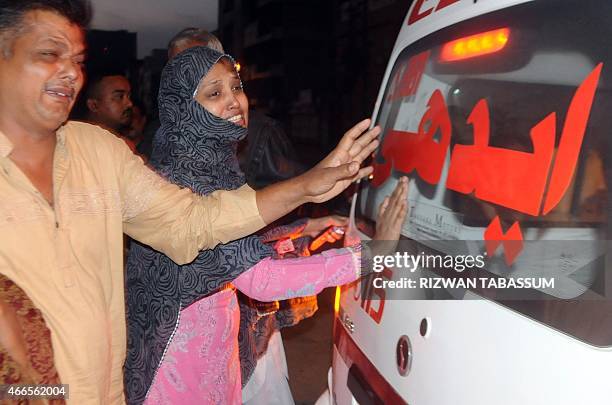Pakistani relatives mourn beside an ambulance carrying the body of convicted murder Muhammad Faisal after his execution in Karachi on March 17, 2015....