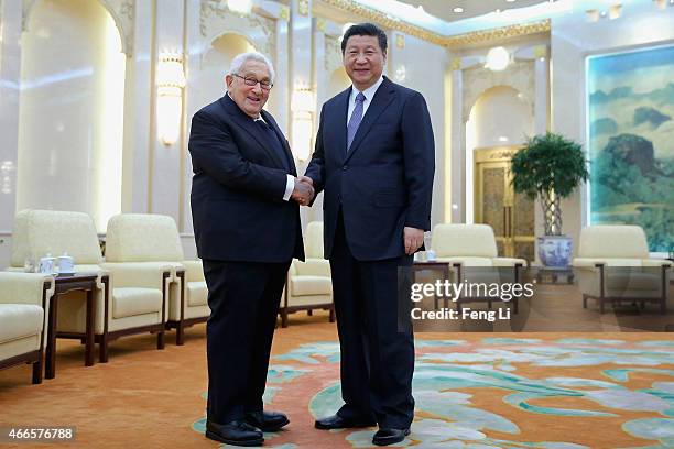 Chinese President Xi Jinping shakes hands with Former United States Secretary of State Henry Kissinger at the Great Hall of the People on March 17,...