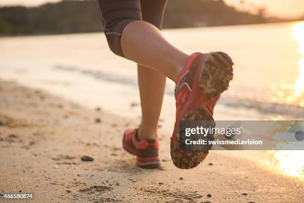 in esecuzione sulla spiaggia al tramonto - fare un passo foto e immagini stock