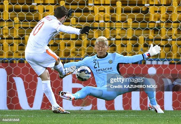 Japan's Kashiwa Reysol goalkeeper Takanori Sugeno tries to block a shot by China's Shandong Luneng FC forward Walter Montillo during their AFC...