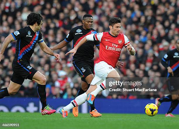 Olivier Giroud of Arsenal breaks past Kagisho Dikgacoi and Mile Jedinak of Crystal Palace during the Barclays Premier League match between Arsenal...