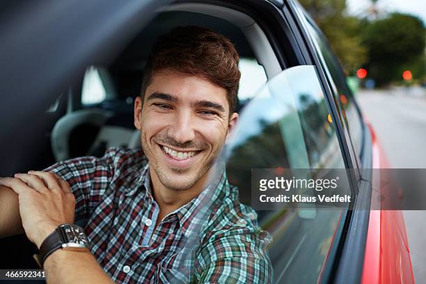 man sitting in red car and laughing - comfortable car stock pictures, royalty-free photos & images