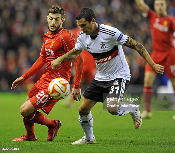 Adam Lallana of Liverpool competes with Ramon Motta of Besiktas during the UEFA Europa League Round of 32 match between Liverpool FC and Besiktas JK...