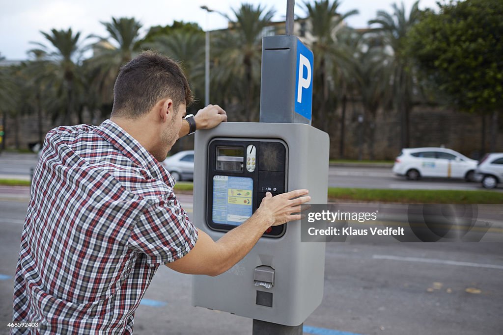 Man feeding parking meter