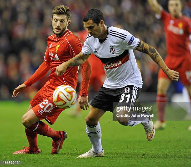 Adam Lallana of Liverpool competes with Ramon Motta of Besiktas during the UEFA Europa League Round of 32 match between Liverpool FC and Besiktas JK...