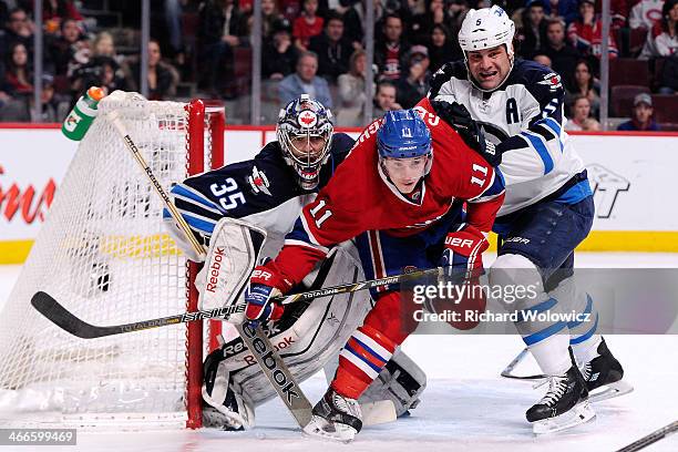 Mark Stuart of the Winnipeg Jets clears Brendan Gallagher of the Montreal Canadiens from in front of goalie Al Montoya of the Winnipeg Jets during...