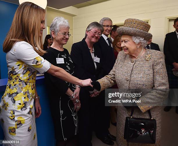 Britain's Queen Elizabeth II meets British actress and patron Amanda Holden as she attends the opening of the new Mary Tealby dog kennels at...