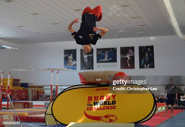 Gymnast Andreea Raducan flips from the vault as she is watched by Rugby Player Ronan O'Gara as they take on the DHL Rugby v's the World Challenge...