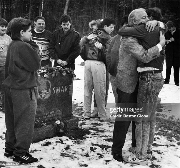 William Smart hugs a relative at the grave of his son, Gregory Smart, at the Forest Hill Cemetery in East Derry, N.H., after his daughter-in-law,...