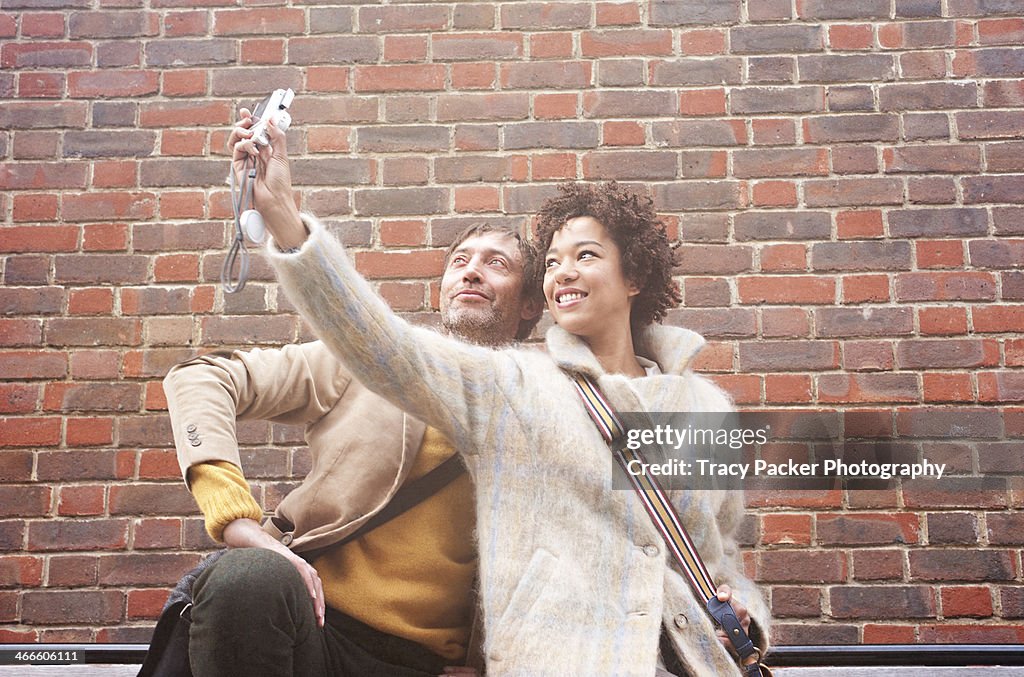 A woman & man take a 'selfie' phone portrait.